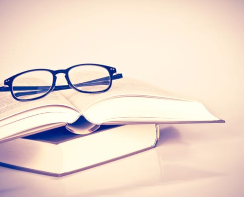black rimmed glasses placed on opened book